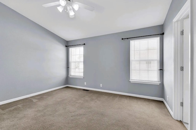 unfurnished room featuring visible vents, carpet, baseboards, ceiling fan, and vaulted ceiling