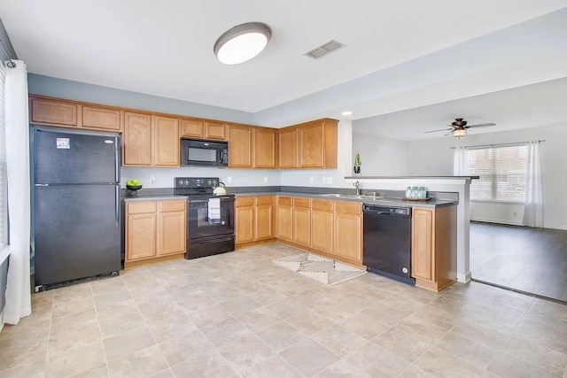 kitchen featuring a ceiling fan, visible vents, a peninsula, a sink, and black appliances