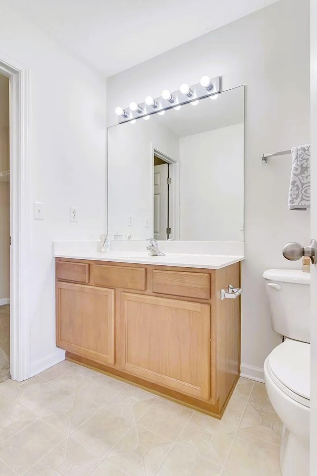 bathroom with vanity, tile patterned floors, toilet, and baseboards