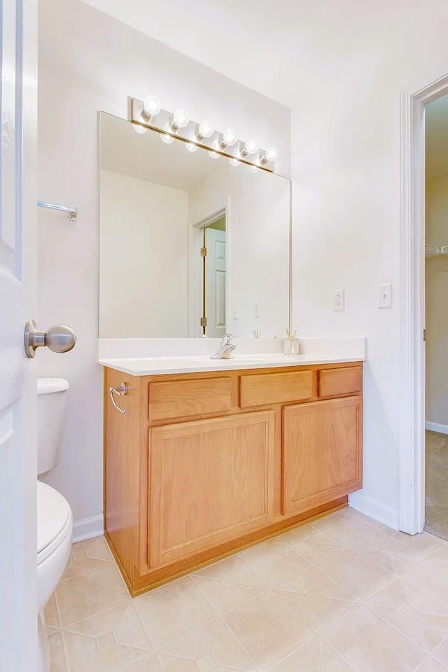 bathroom with vanity, toilet, and baseboards