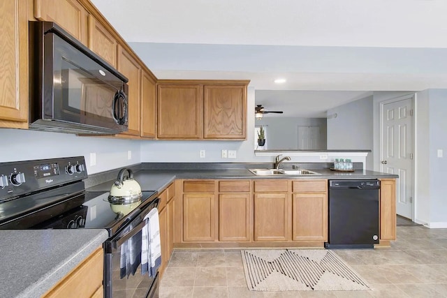 kitchen featuring black appliances, a sink, dark countertops, a peninsula, and ceiling fan