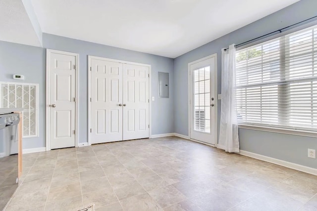 interior space with electric panel and baseboards