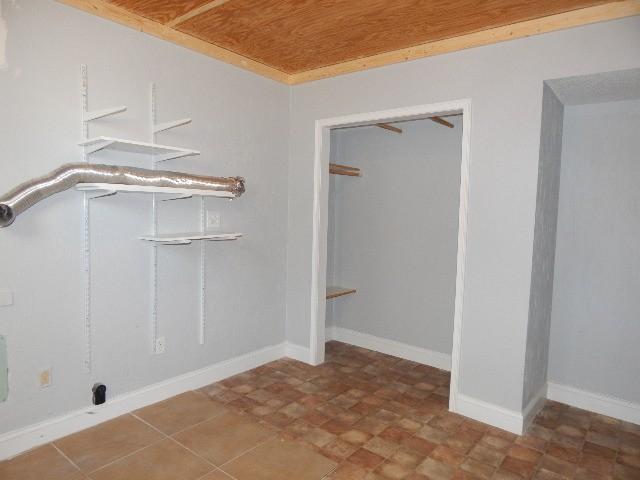 washroom featuring baseboards, wood ceiling, and laundry area