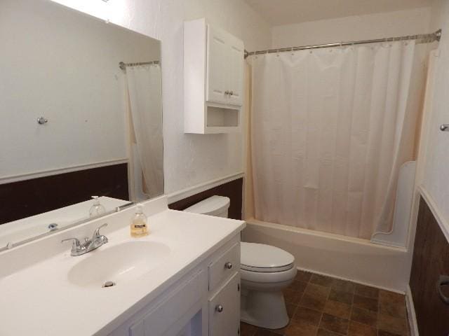 bathroom featuring vanity, toilet, and shower / bath combo with shower curtain