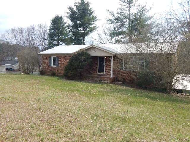 view of front of house with a front yard and brick siding