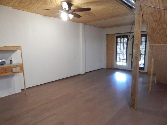 spare room with wood finished floors, wooden ceiling, and a ceiling fan