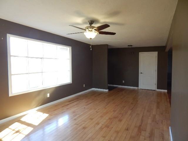 spare room with light wood-style floors, baseboards, and ceiling fan