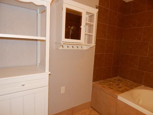 bathroom with tile patterned floors, a bath, and tiled shower