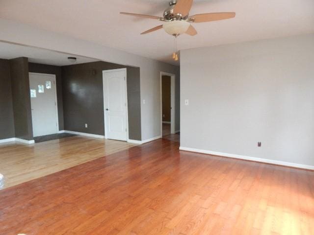 spare room with ceiling fan, baseboards, and wood finished floors