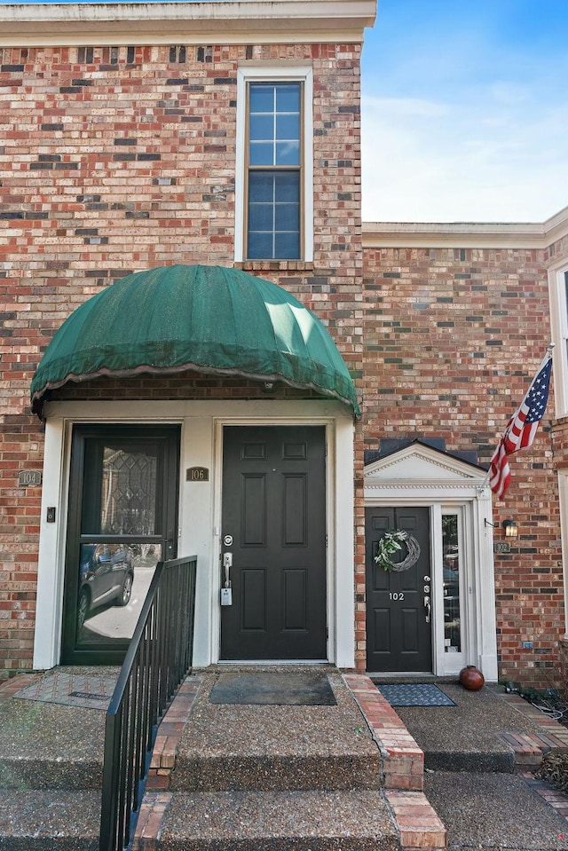 property entrance featuring brick siding