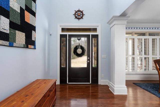 entryway featuring decorative columns, baseboards, and wood finished floors