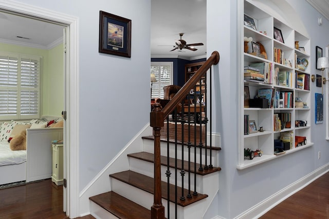 staircase with crown molding, wood finished floors, a ceiling fan, and baseboards