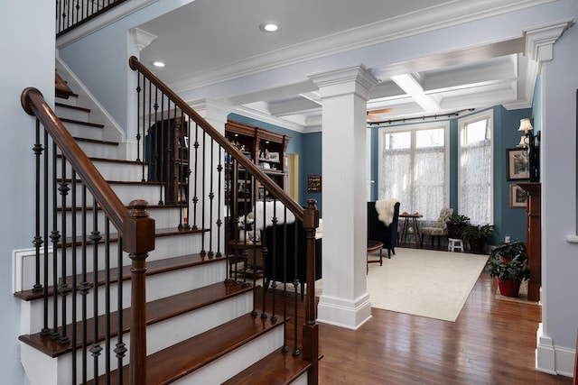 stairs with beamed ceiling, coffered ceiling, wood finished floors, crown molding, and decorative columns