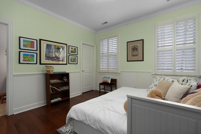 bedroom with visible vents, dark wood-style floors, a wainscoted wall, and ornamental molding