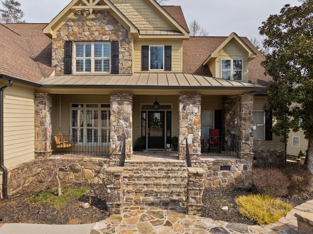 craftsman house with stone siding, a porch, a standing seam roof, and roof with shingles