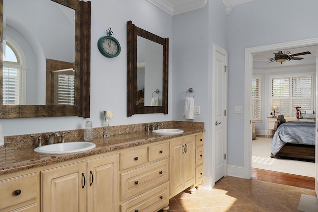 ensuite bathroom featuring ornamental molding, a stall shower, and a sink