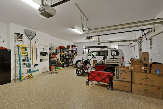 garage with a garage door opener and freestanding refrigerator