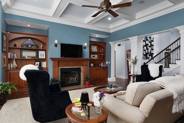 living room with a premium fireplace, decorative columns, wood finished floors, and ceiling fan