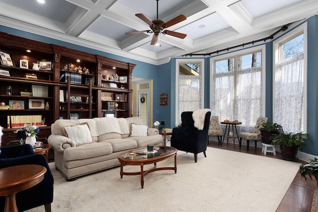 living area with beamed ceiling, coffered ceiling, wood finished floors, and a ceiling fan