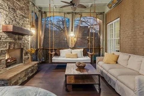 sunroom with a fireplace and ceiling fan