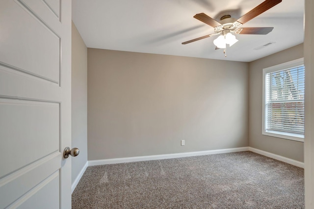 carpeted spare room with visible vents, baseboards, and ceiling fan