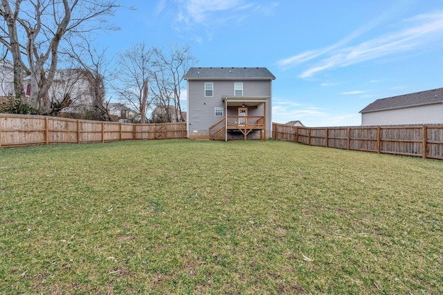 rear view of house featuring a fenced backyard and a yard