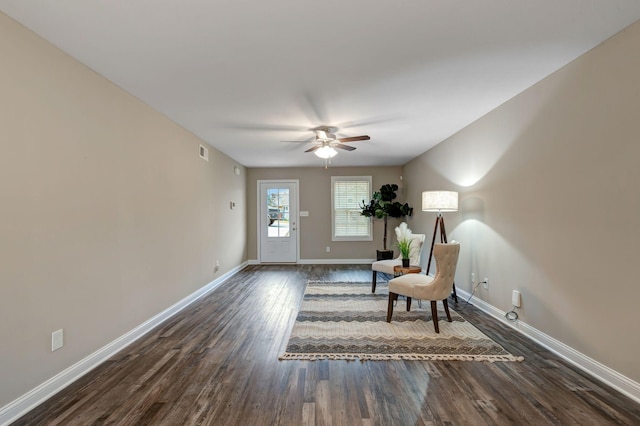 sitting room with visible vents, baseboards, dark wood finished floors, and a ceiling fan