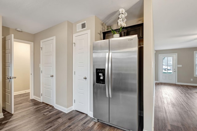 kitchen with visible vents, dark wood-style flooring, baseboards, and stainless steel fridge with ice dispenser