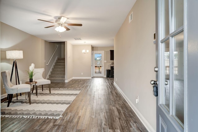 foyer entrance with dark wood-style floors, visible vents, baseboards, ceiling fan, and stairs