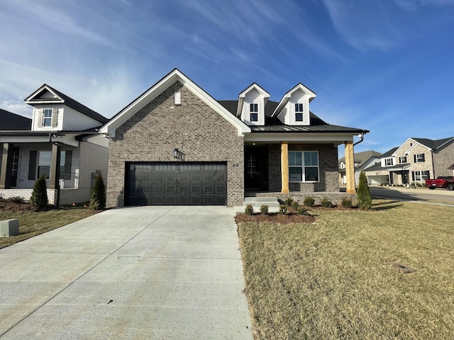 view of front of property featuring metal roof, concrete driveway, a front yard, a garage, and brick siding