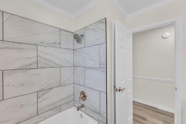 full bathroom with washtub / shower combination, crown molding, baseboards, and wood finished floors