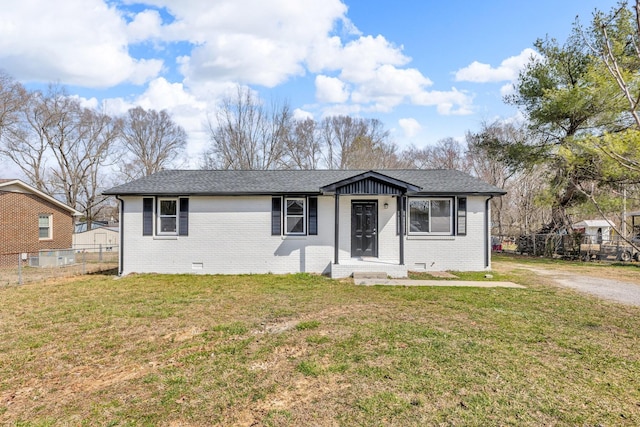 ranch-style home with fence, a front yard, a shingled roof, crawl space, and brick siding