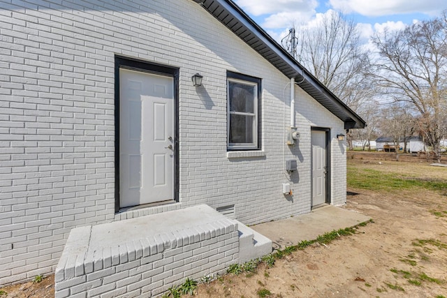 doorway to property featuring brick siding