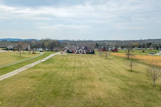 view of property's community featuring a yard and a rural view