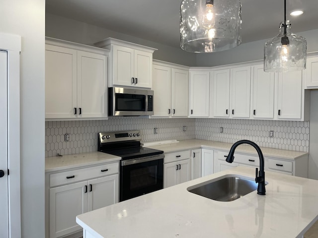 kitchen with a sink, stainless steel microwave, range with electric stovetop, white cabinetry, and decorative backsplash