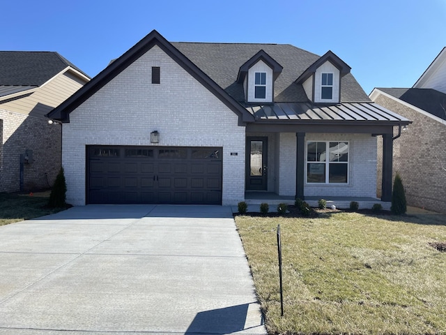 view of front facade with brick siding, concrete driveway, metal roof, an attached garage, and a standing seam roof