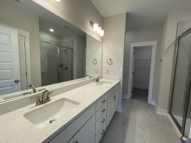 full bathroom with a shower stall, a walk in closet, and a sink