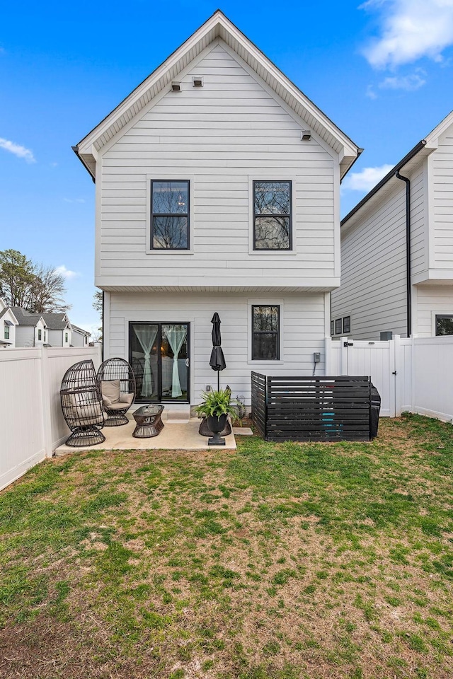 back of property with a patio area, a lawn, a fenced backyard, and an outdoor fire pit