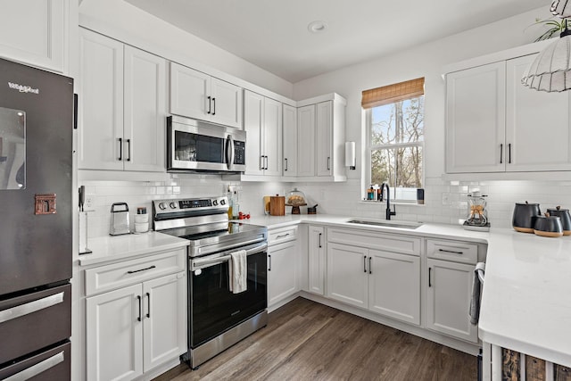 kitchen with light countertops, white cabinets, appliances with stainless steel finishes, and a sink