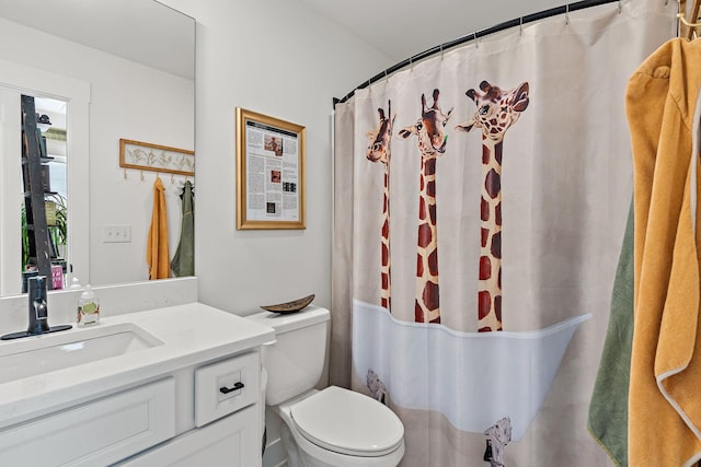 bathroom featuring vanity, curtained shower, and toilet