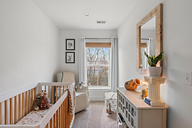 bedroom featuring visible vents, a crib, carpet, and baseboards