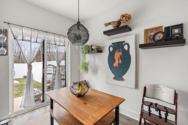 dining room with baseboards, plenty of natural light, and wood finished floors