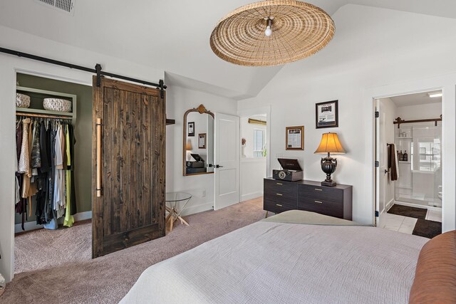 carpeted bedroom featuring a barn door, lofted ceiling, a closet, and a walk in closet