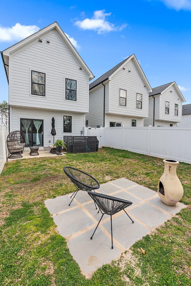 back of property featuring a patio area, a lawn, a fenced backyard, and an outdoor fire pit