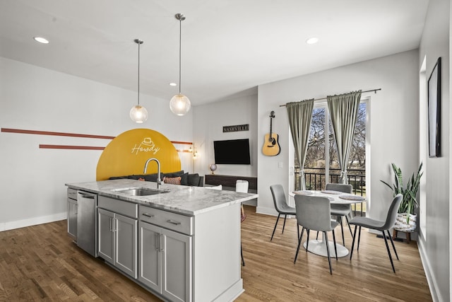 kitchen with dark wood-style floors, baseboards, gray cabinetry, a sink, and stainless steel dishwasher