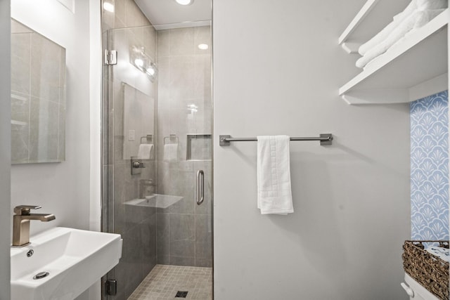 bathroom with a stall shower and a sink