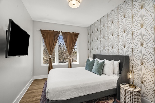 bedroom with baseboards and wood finished floors