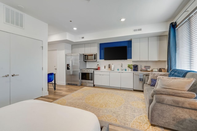 kitchen featuring light wood finished floors, visible vents, white cabinetry, and stainless steel appliances