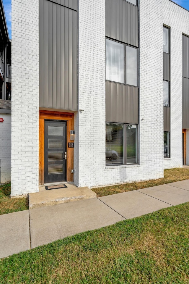 entrance to property with brick siding and board and batten siding