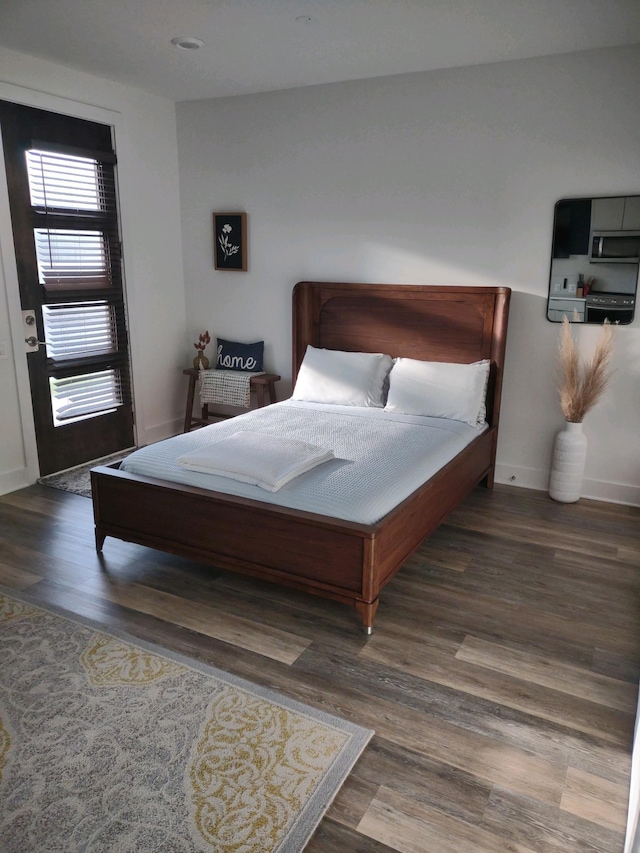 bedroom with baseboards and wood finished floors